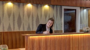 En receptionsdisk med träinredning och ett glasmontrinskåp.