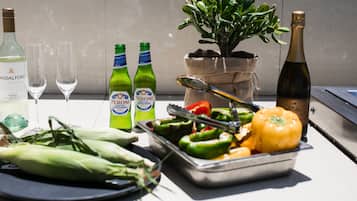 Una mesa con botellas de cerveza Peroni, una botella de vino y una planta en una bolsa de arpillera.