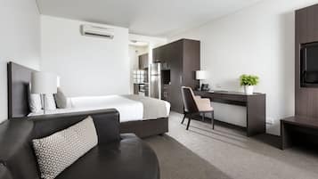 Una habitación de hotel moderna con una cama, un escritorio, una silla y un televisor.