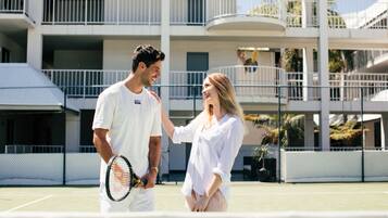 A tennis court with a building in the background.