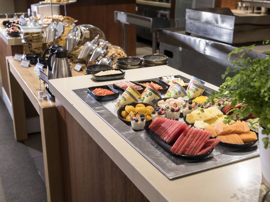 Un buffet proposant une variété de plats, notamment des fruits, des fromages et des viandes.
