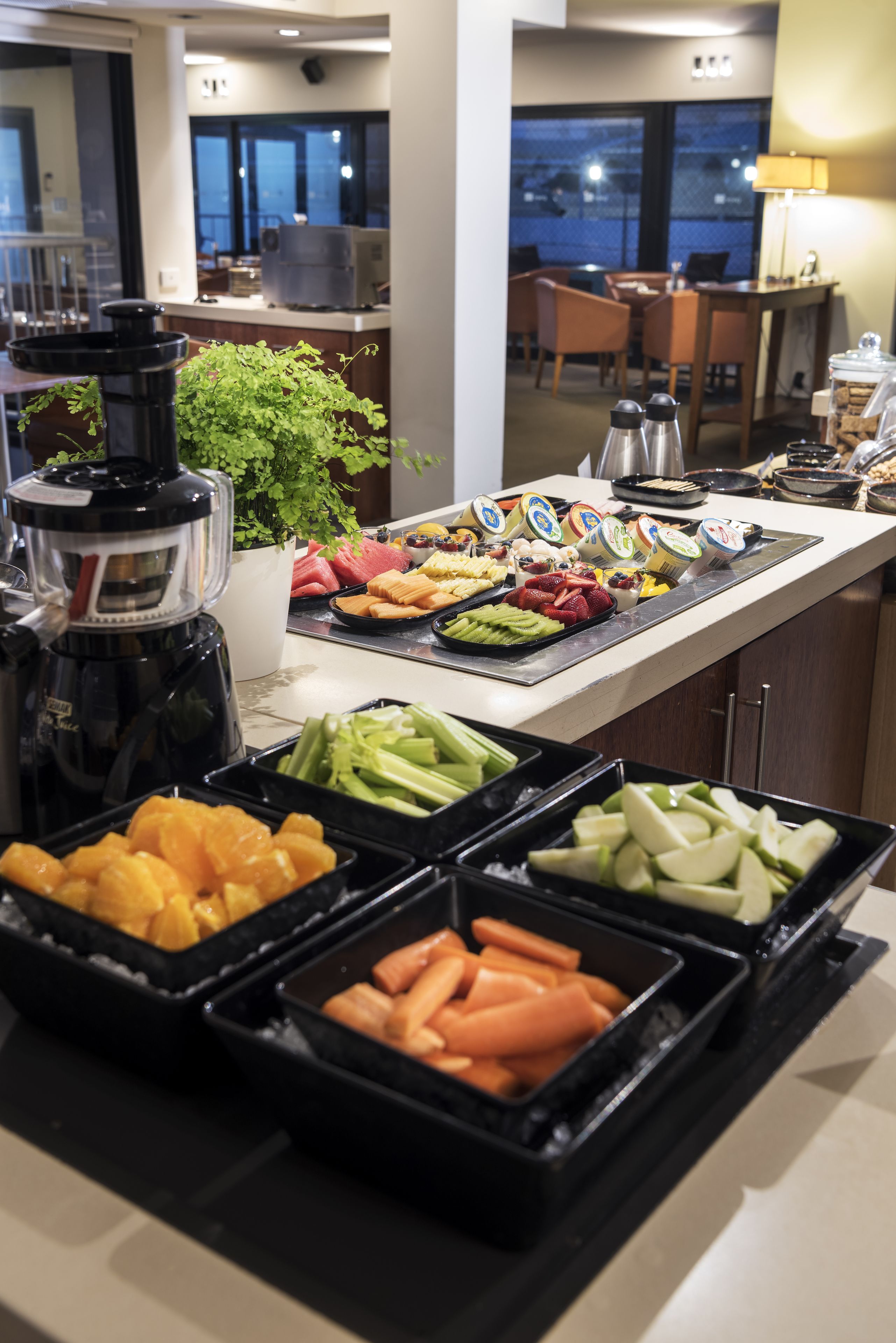 A buffet with various food items and a coffee maker.