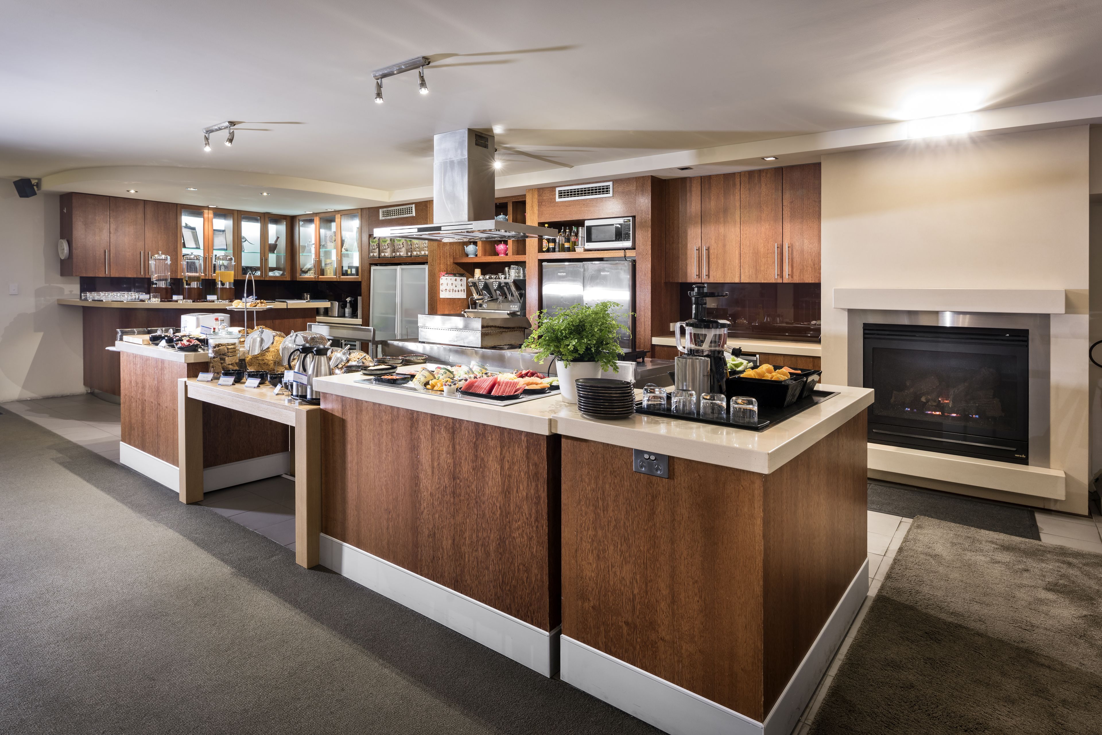 A modern kitchen with a central island, built-in appliances, and a fireplace.