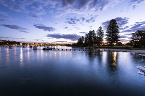A calm waterfront with boats, a dock, and trees under a twilight sky. - Pier 21 Riverside Apartment Hotel (North Fremantle)