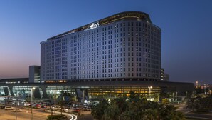 Un hôtel de grande hauteur au design moderne, caractérisé par une vaste façade en verre et de nombreux étages.