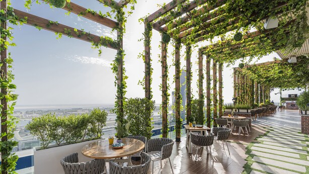 A rooftop terrace with a wooden pergola, outdoor seating, and a view of the cityscape. - Aloft by Marriott Abu Dhabi (Abu Dhabi)