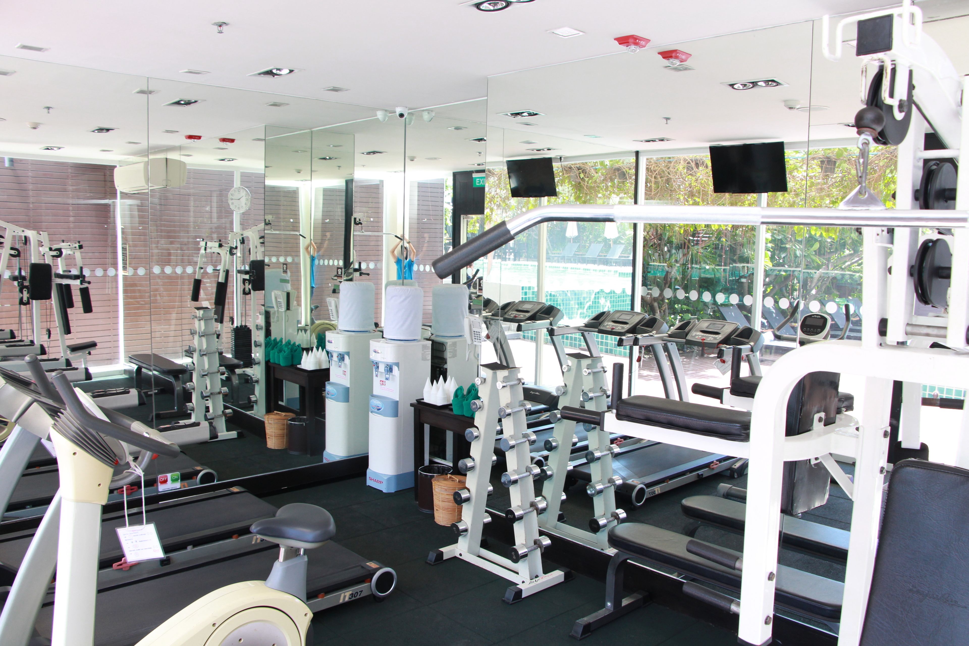 A gym with treadmills, weight machines, and mirrors.