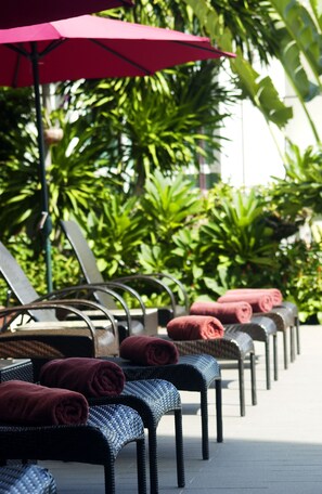 室外游泳池，池畔遮阳伞，日光浴躺椅