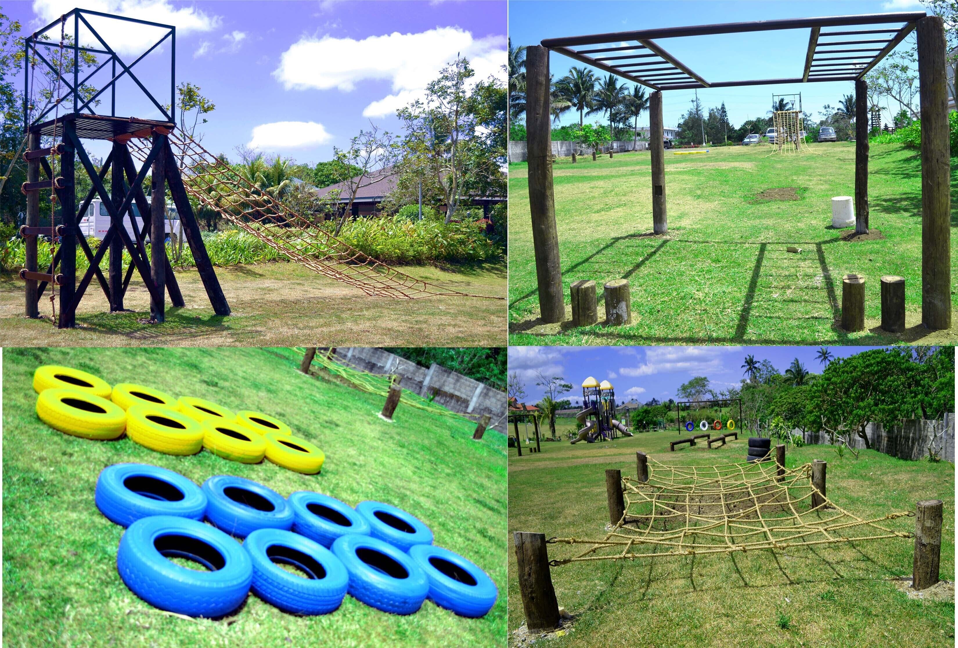 A playground with a climbing structure, tire maze, and a netted obstacle course.