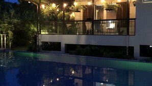 A modern house with a swimming pool, large windows, and outdoor lighting. - Hotel Kimberly Tagaytay (Tagaytay)