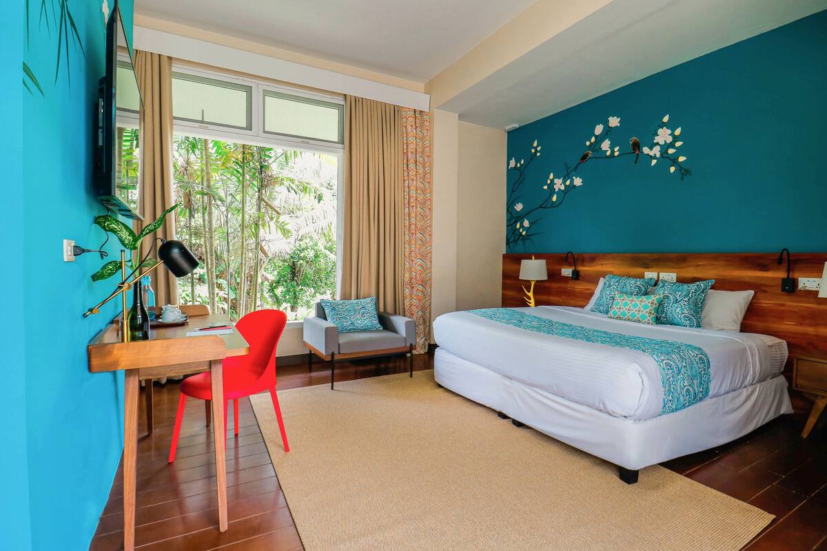 Une chambre à coucher avec un lit, un bureau, une chaise et un téléviseur.