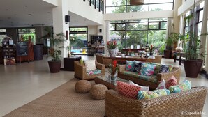 A spacious lobby with wicker furniture, large windows, and indoor plants. - Hotel Kimberly Tagaytay (Tagaytay)