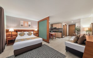 A hotel room with a bed, bedside tables, a desk, a chair, a small kitchen area, and a bathroom. - Hotel Kimberly Manila (Manila)