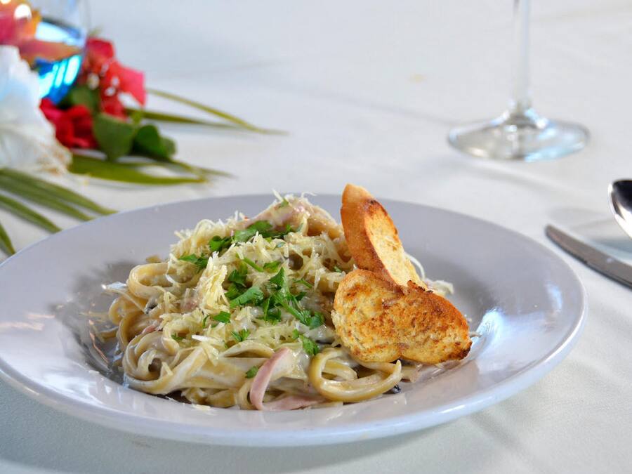 Un plato de pasta con pan sobre una mesa.
