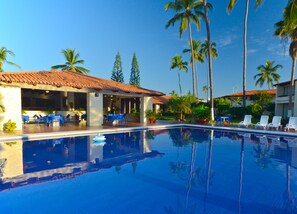 Una piscina al aire libre, sombrillas, tumbonas