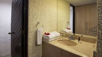 Un baño con pared de color beige con textura, un lavabo con espejo y una puerta de madera.