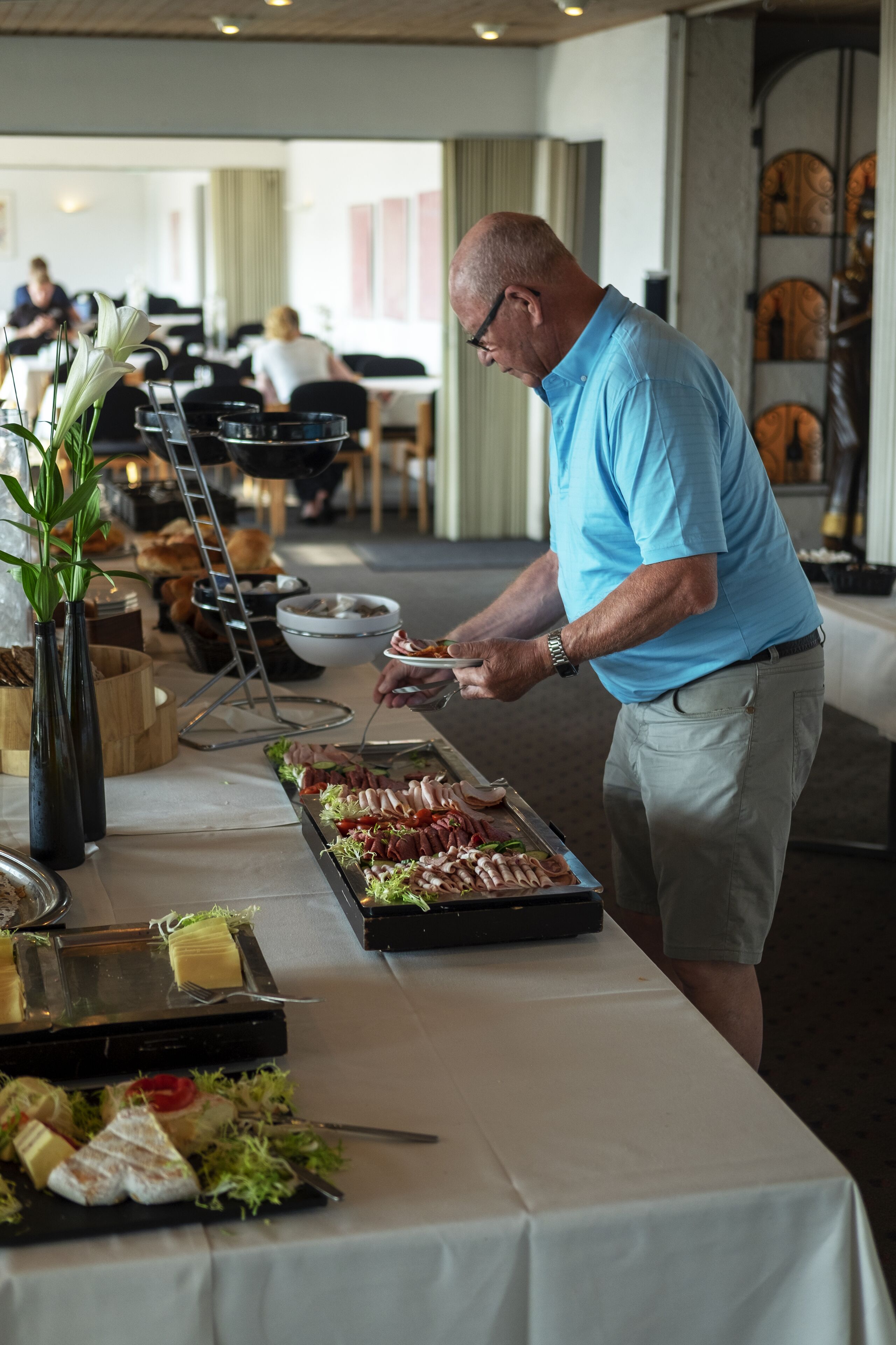Un buffet proposant une variété de plats et un homme qui sert les aliments.
