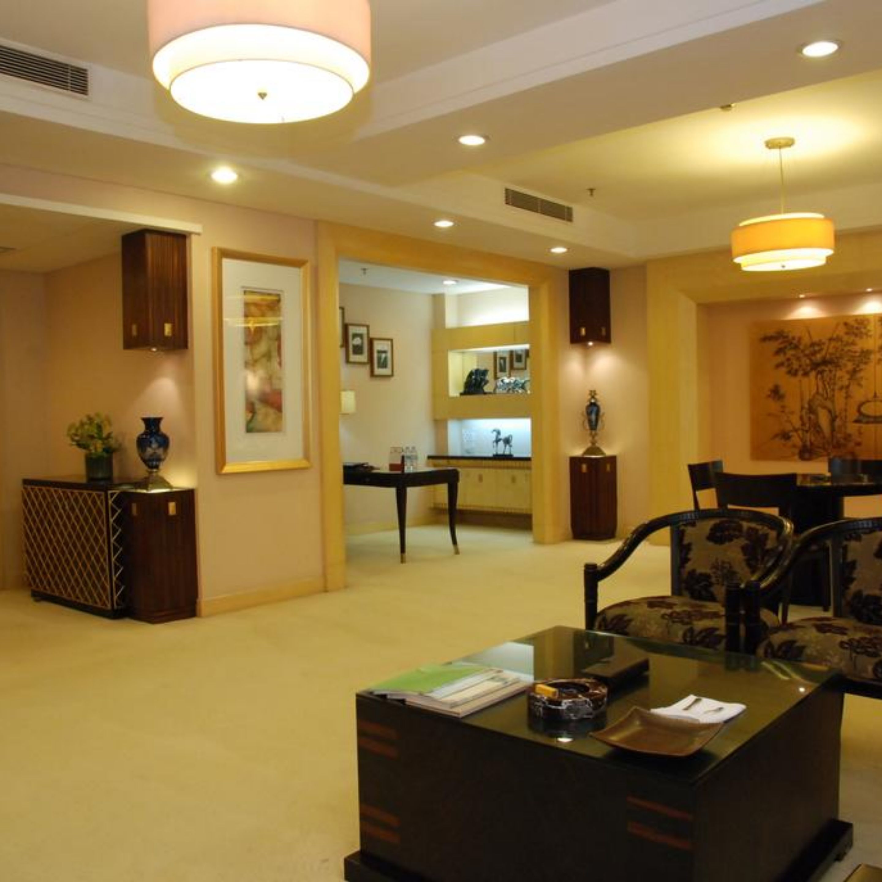 A hotel lobby with a reception desk, seating area, and a dining area.