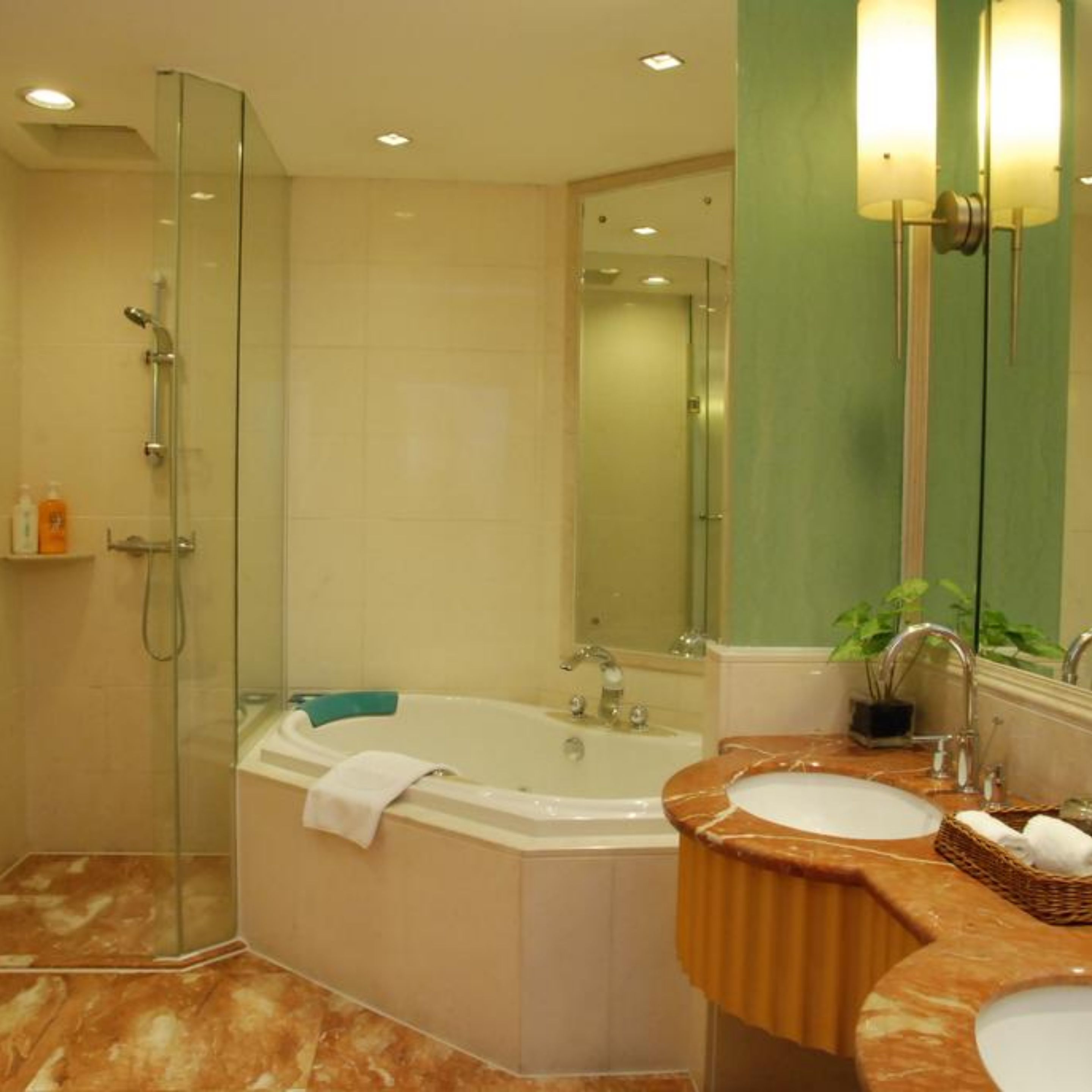 Un baño con ducha de vidrio, bañera independiente y tocador con lavamanos y espejo.