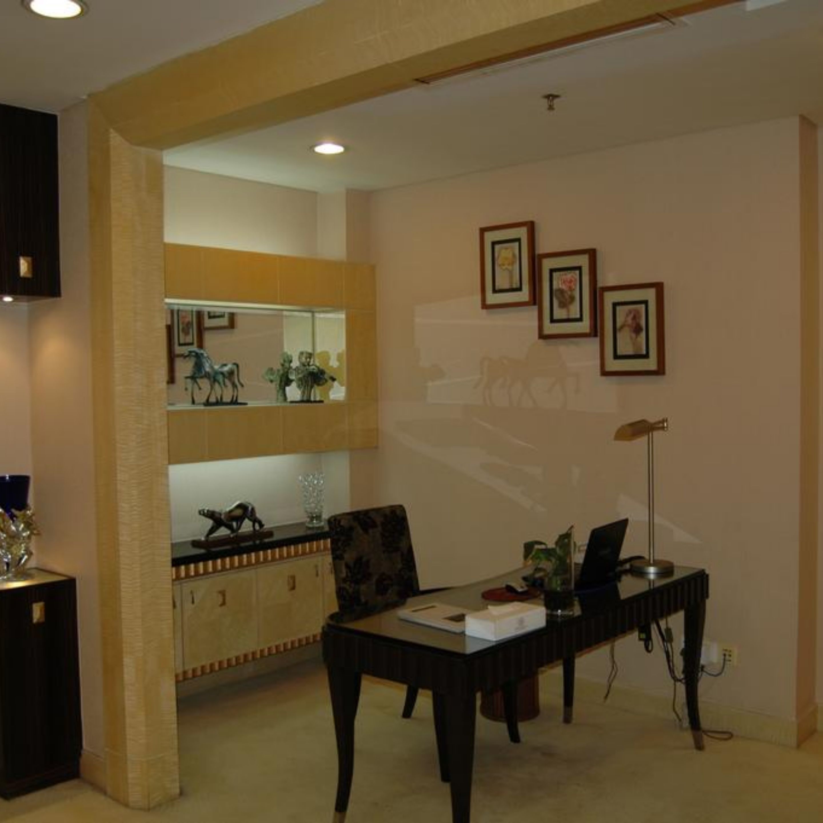 A dining area with a table, chairs, and a kitchen area in the background.