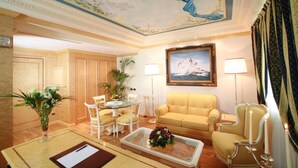 A luxurious room with a dining area, a sofa, a chair, and a painting on the wall. - Grand Hotel del Parco - Bergamo Airport (Stezzano)