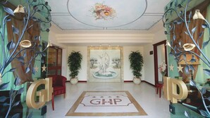 A hotel lobby with a central fountain, a red chair, and decorative plants. - Grand Hotel del Parco - Bergamo Airport (Stezzano)
