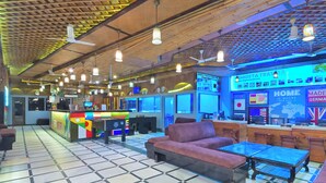 Eine Lobby mit Empfangstresen, Sitzgelegenheiten und einer digitalen Anzeigetafel.