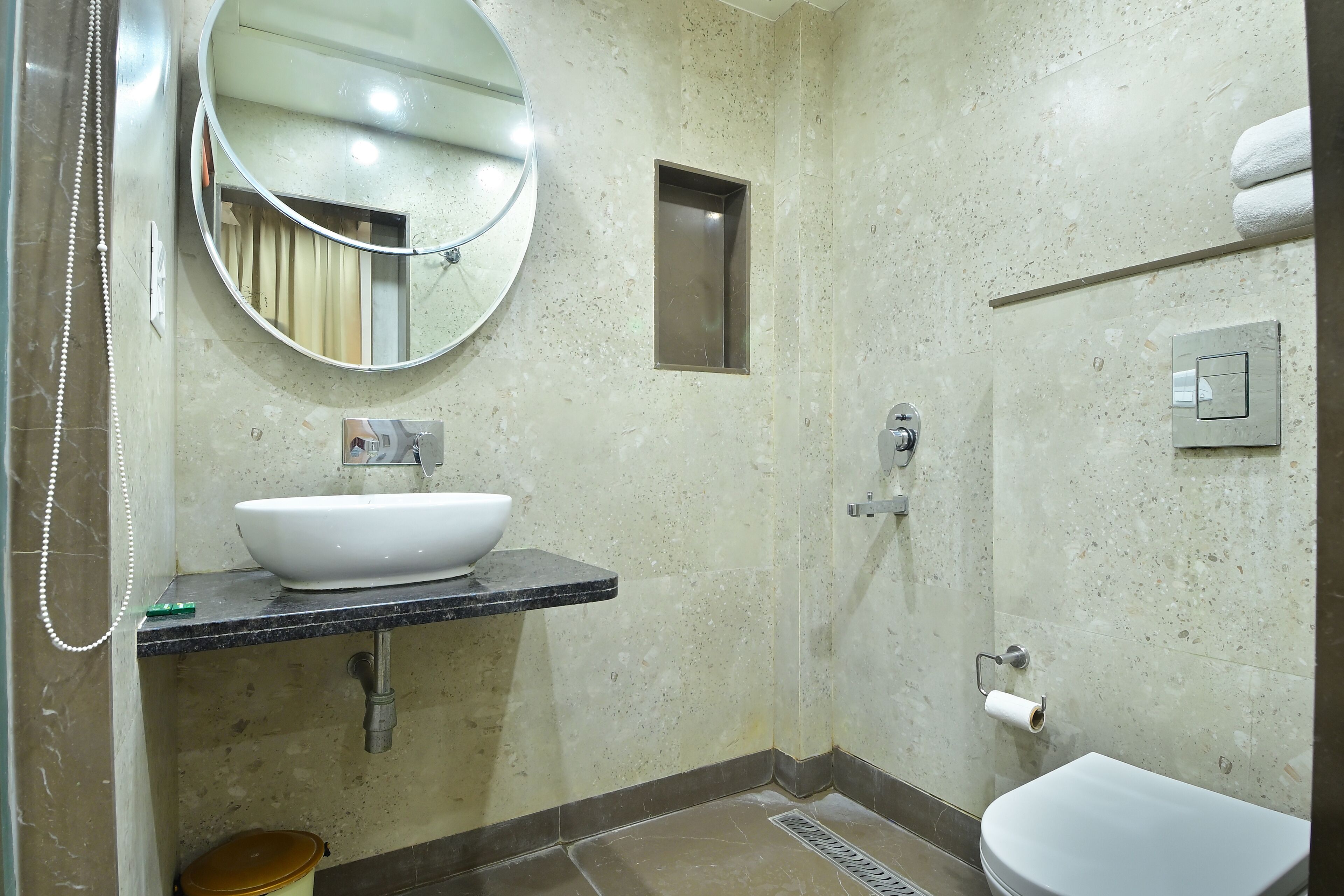 Une salle de bain équipée d’un lavabo, d’un miroir, de toilettes et d’un espace douche.