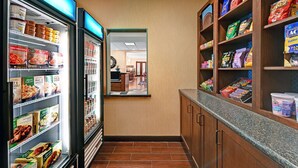 A grocery store with refrigerated sections on the left and shelves stocked with snacks and dairy products on the right. - Hampton Inn Deming (Deming)
