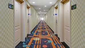 A hotel hallway with checkered walls, numbered doors, and a colorful carpet. - Hampton Inn Deming (Deming)