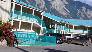 A hotel with multiple balconies and a mountain backdrop. - Canadas Best Value Inn Mile 0 (Lillooet)