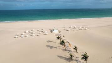 On the beach, white sand, sun-loungers, beach umbrellas