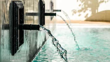 A pool with clear water and a faucet.