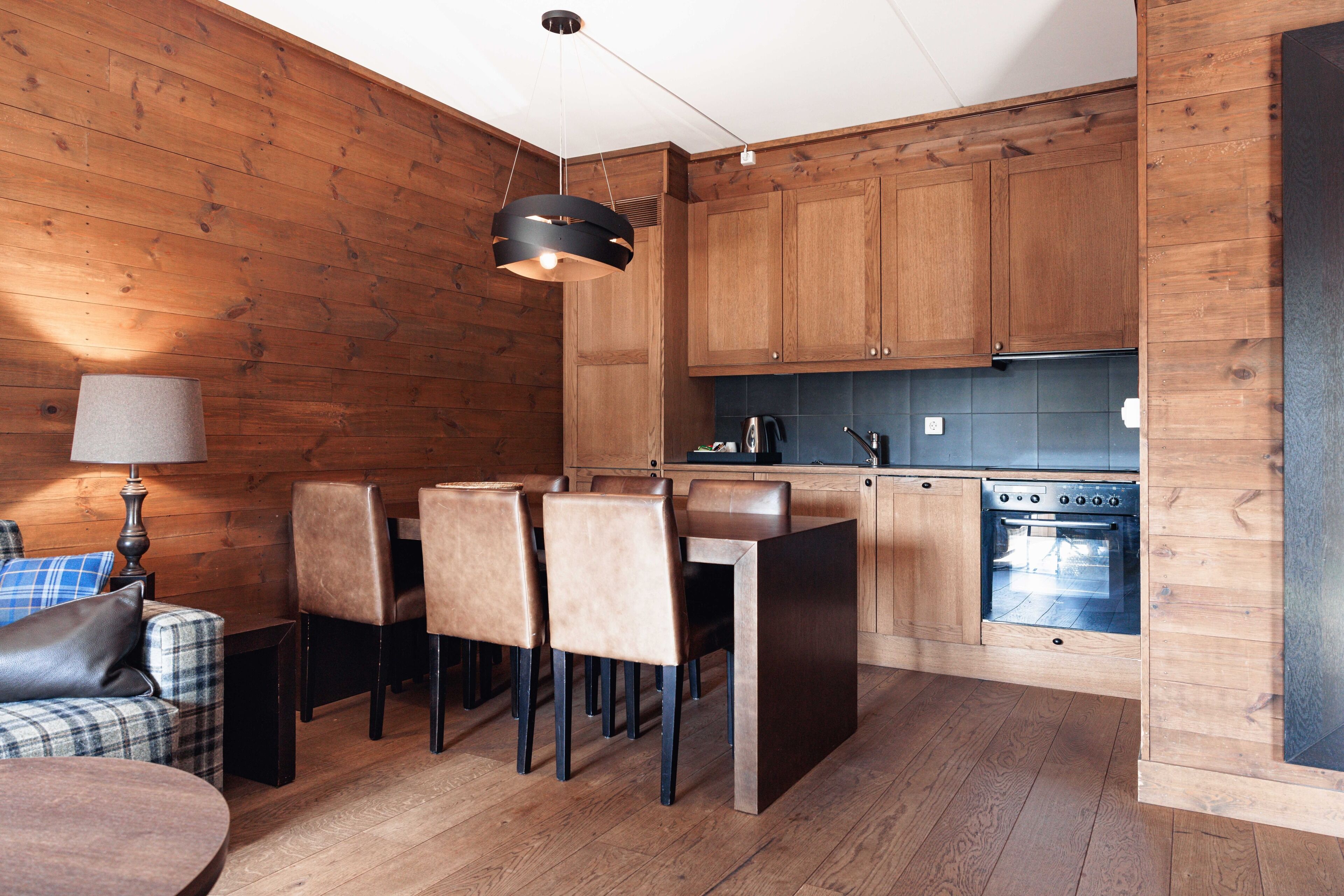Une cuisine moderne avec des meubles en bois, un coin repas avec des chaises et une table ronde.