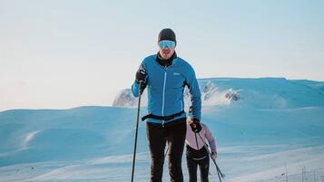 Una persona esquiando en una pendiente nevada bajo un cielo despejado.