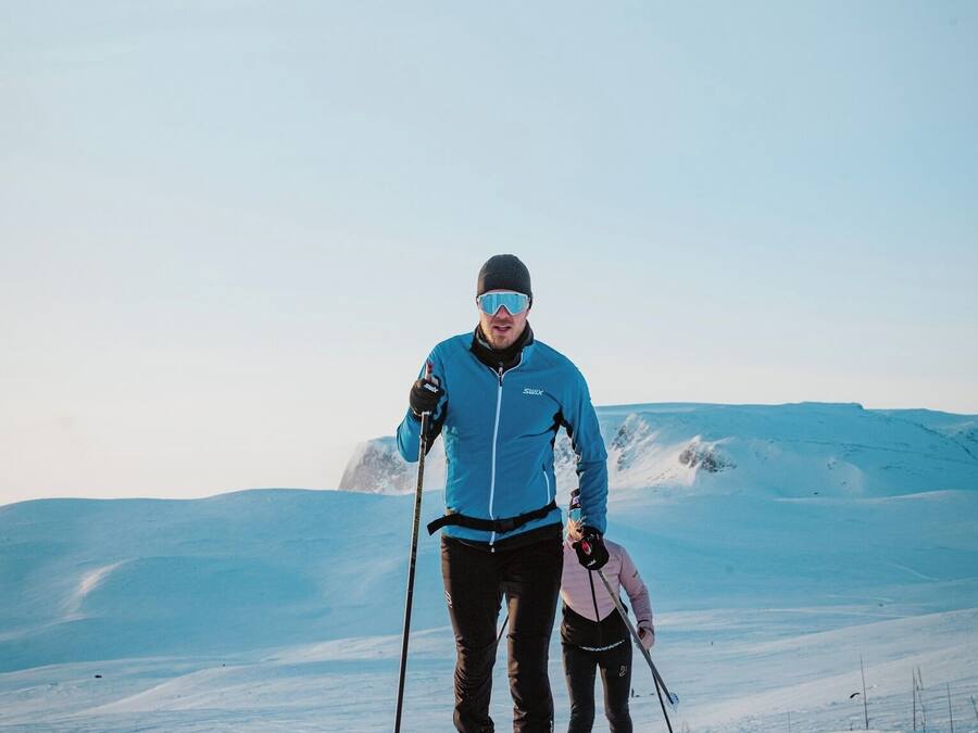 Una persona esquiando en una pendiente nevada bajo un cielo despejado.