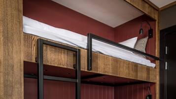 Een stapelbed met een houten frame en rode wanden.