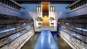 A traditional building with a central staircase, stone walls, and illuminated blue lights.