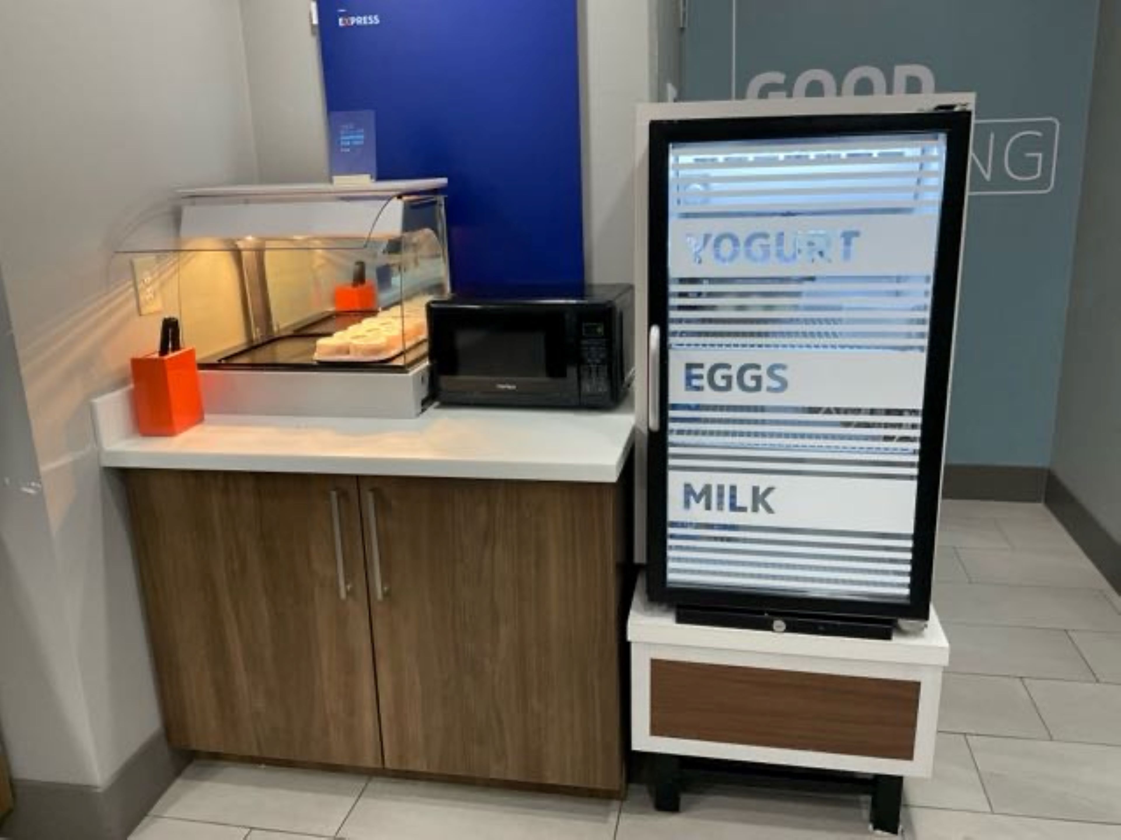 A self-service breakfast station with a digital menu display listing yogurt, eggs, and milk.