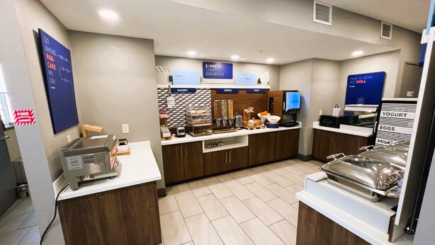 A modern breakfast area with a bakery, cereal, and fruit display, a coffee machine, and a yogurt and egg station. - Holiday Inn Express Wichita North - Park City by IHG (Wichita)