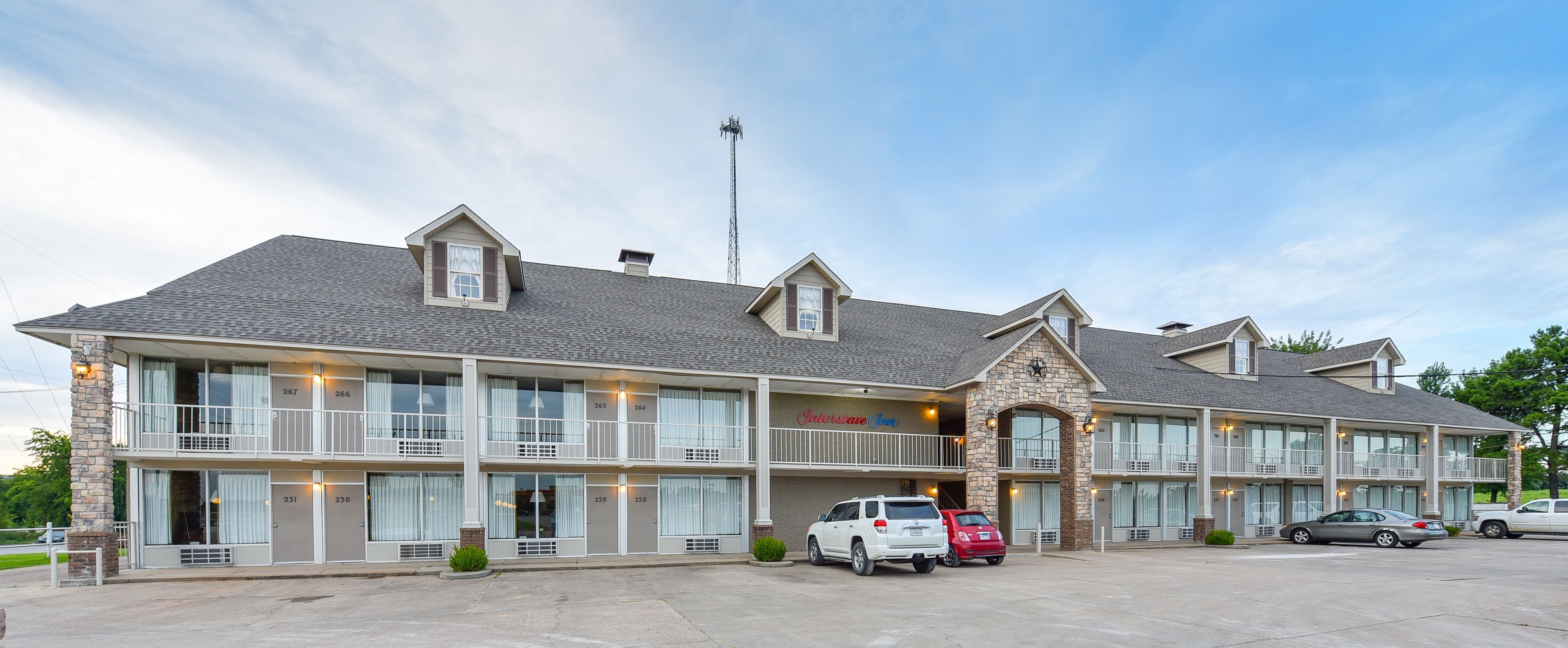 Een motel met meerdere verdiepingen, grote ramen en een gevel van natuursteen.