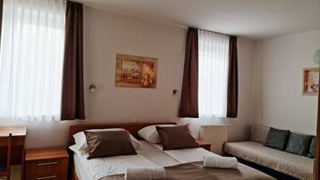 Ein Hotelzimmer mit Bett, Schreibtisch, Sessel, Sofa und einem Bild an der Wand.
