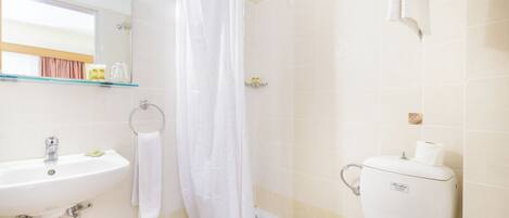 A bathroom with a sink, toilet, and shower curtain.