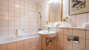 Een badkamer met een bad, wastafel en spiegel.