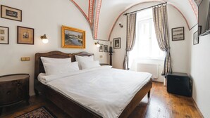 Un dormitorio con una cama de madera, una mesita de noche, un radiador y una maleta.
