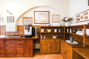 Una cocina con armarios de madera, una cafetera y diversos electrodomésticos.