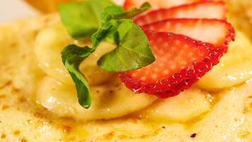 A dessert with banana slices, strawberries, and mint leaves.