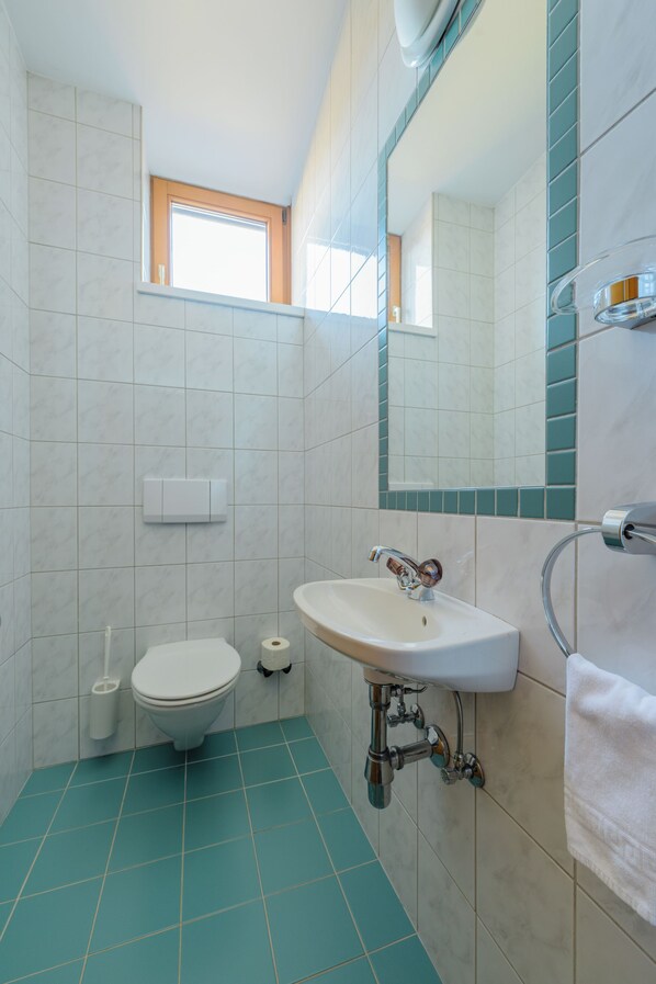 Un baño con inodoro, lavamanos y ventana.