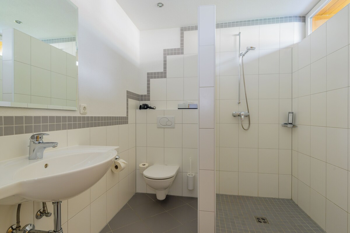 Un baño con lavamanos, inodoro y ducha.