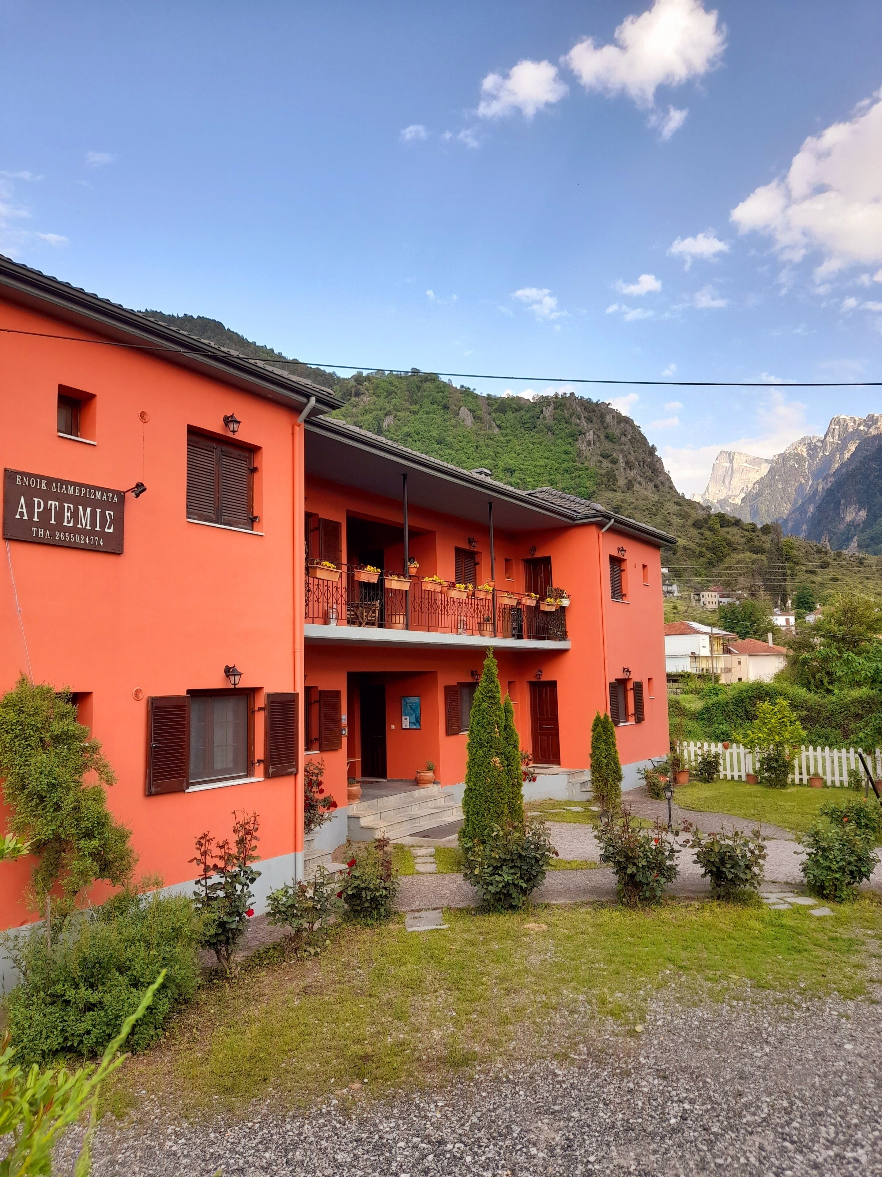 A two-story building with a sign reading "APTEMIE" and a mountain backdrop.